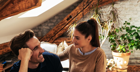Couple looking at each other with laptop